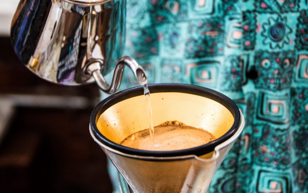 Préparation d'un café à l'aide d'un filtre réutilisable en métal doré, Revolver Cafe, Cambie Street, Vancouver, Canada.