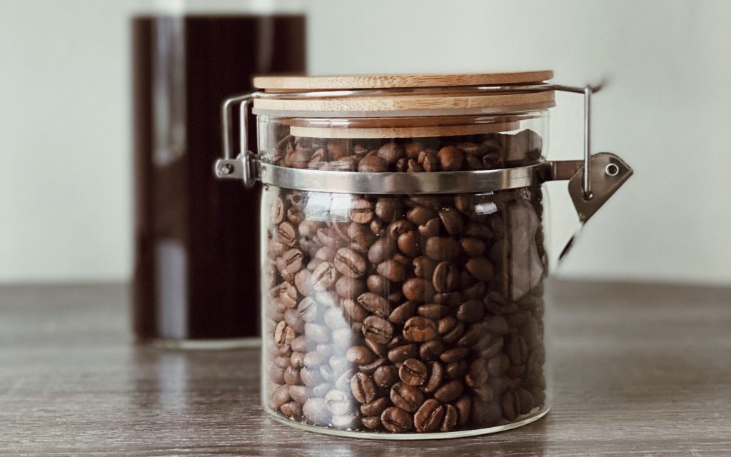 un récipient en verre rempli de grains de café