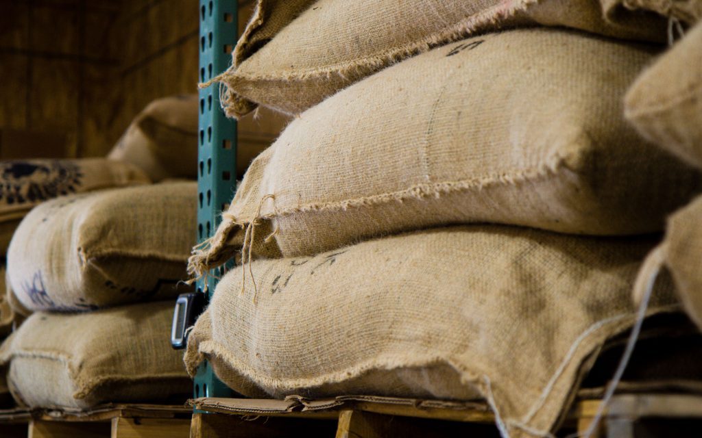 Sacs de jute de café vert stockés dans un entrepôt.