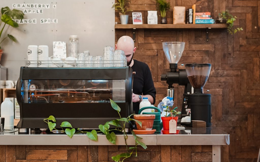 Un barista utilise une machine à expresso dans un café.